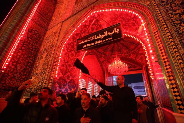 Shiite worshippers take part during a ritual commemorating the 7th century killing of Imam Ali, the cousin, son-in-law, and companion of the Prophet Muhammad, during the Muslim month of Ramadan in Iraq's holy city of Najaf on March 10, 2026. (Photo by AHMAD AL-RUBAYE / AFP)
