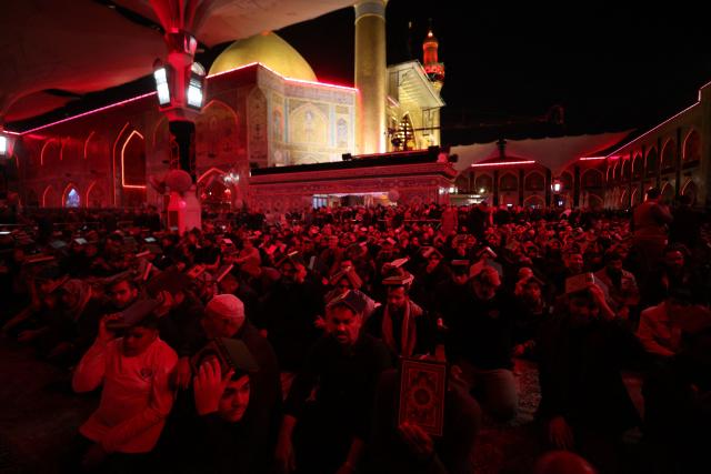 Shiite worshippers place copies of the Koran, Islam's holy book, on their heads during a ritual commemorating the 7th century killing of Imam Ali, the cousin, son-in-law, and companion of the Prophet Muhammad, during the Muslim month of Ramadan in Iraq's holy city of Najaf on March 10, 2026. (Photo by AHMAD AL-RUBAYE / AFP)