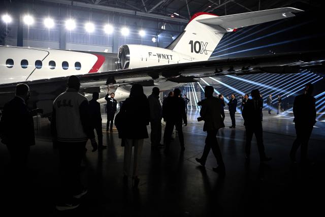 Guests look at Dassault Aviation's new business aircraft the Falcon 10X during its unveiling ceremony  at Dassault headquarters in Bordeaux, south-western France on March 10, 2026. Master of the Rafale fighter jets, French manufacturer Dassault has unveiled the Falcon 10X, its latest private jet. Rarer and more expensive than those of its North American competitors, it is eagerly awaited for its military-grade performance in a growing market. (Photo by Christophe ARCHAMBAULT / AFP)