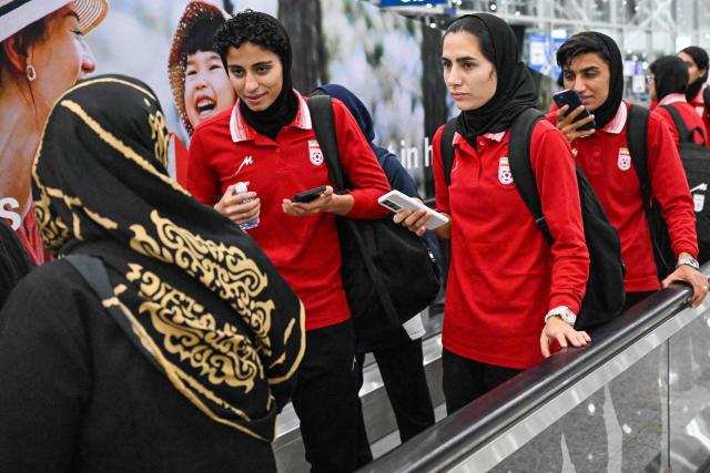 Members of Iran's women's football arrive at the Kuala Lumpur International Airport after taking part in the AFC Women’s Asian Cup Australia 2026 tournament in Australia, in Sepang on March 11, 2026. At least five players from Iran's visiting women's football team claimed asylum in Australia on on March 10, seeking protection after they were branded "traitors" at home for refusing to sing the national anthem. (Photo by Mohd RASFAN / AFP)