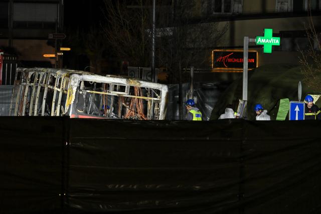 Forensic officers work in a cordoned-off area inside a bus that caught fire, killing at least six people and injuring five others in what police said may have been a deliberate act, in the town of Kerzers, western Switzerland, on March 11, 2026. A bus caught fire in western Switzerland on March 10 killing at least six people and injuring five others in what police said may have been a deliberate act. The fire broke out on the bus in the main street of the small town of Kerzers, around 20 kilometres (12 miles) west of the Swiss capital Bern, at about 6:25 pm (1725 GMT). (Photo by Fabrice COFFRINI / AFP)