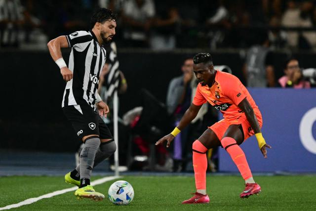 Botafogo's defender #13 Alex Telles and Barcelona's defender #18 Bryan Carabali fight for the ball during the Copa Libertadores phase three second-leg football match between Brazil's Botafogo and Ecuador's Barcelona at the Nilton Santos Stadium in Rio de Janeiro, Brazil on March 10, 2026. (Photo by Pablo PORCIUNCULA / AFP)