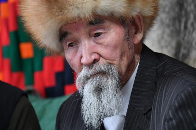 Tashtanbek, 88, patriarch of the Akmatov family of white yaks breeders, talks to AFP reporters in his house in the mountainous Kyrgyz village of Kara-Saz on February 2, 2026. (Photo by Vyacheslav OSELEDKO / AFP)