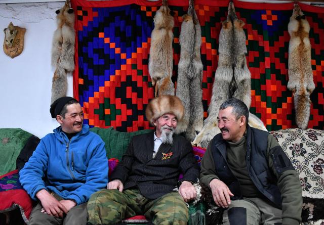 Amantur, 30, Tashtanbek, 88, and Baatyrbek, 52, of the Akmatov family of white yaks breeders, smile sitting in their house in the mountainous Kyrgyz village of Kara-Saz on February 2, 2026. (Photo by Vyacheslav OSELEDKO / AFP)