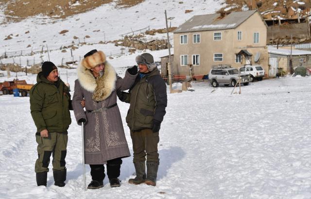 Baatyrbek, 52, Tashtanbek, 88, and Amantur, 30, of the Akmatov family of white yaks breeders, are seen in front of their house in the mountainous Kyrgyz village of Kara-Saz on February 3, 2026. (Photo by Vyacheslav OSELEDKO / AFP)