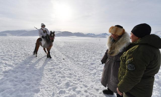 Amantur, 30, Tashtanbek, 88, and Baatyrbek, 52, of the Akmatov family of white yaks breeders, are seen in the mountainous Kyrgyz village of Kara-Saz on February 3, 2026. (Photo by Vyacheslav OSELEDKO / AFP)