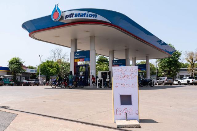 TOPSHOT - A handwritten sign reading "Diesel run out and gasoline run out" is displayed at a PTT gas station in the Donkoi district of Vientiane on March 10, 2026, amid rising petrol prices. The spike in oil prices caused by the war in the Middle East has provoked anxiety in many drivers across Asia. (Photo by AFP)