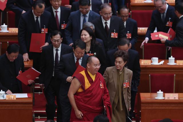 The Chinese government-selected 11th Panchen Lama Gyaincain Norbu (front C) and other delegates leave at the end of the closing session of the Chinese People's Political Consultative Conference (CPPCC) at the Great Hall of the People in Beijing on March 11, 2026. (Photo by Lintao Zhang / POOL / AFP)