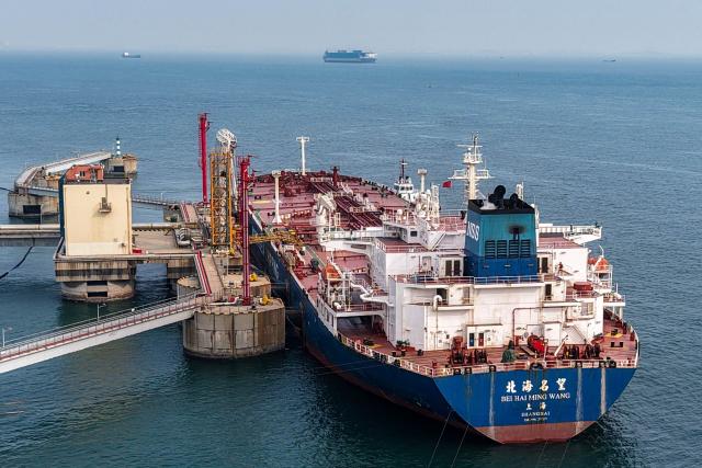 An oil tanker unloads crude oil at a terminal at the port in Qingdao, in China’s eastern Shandong province on March 11, 2026. (Photo by CN-STR / AFP) / China OUT