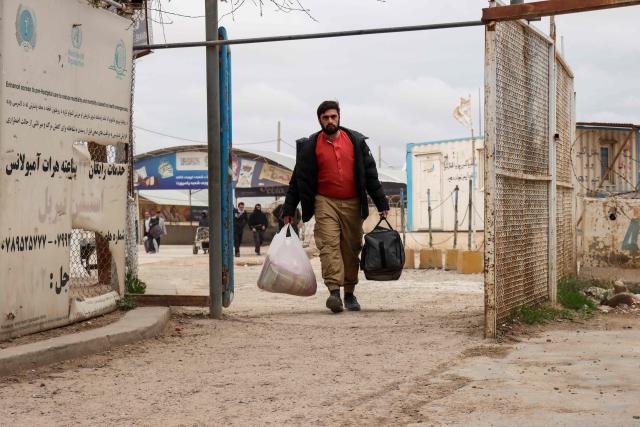 An Afghan national arrives with his belongings at the Islam Qala border crossing between Afghanistan and Iran in Herat province on March 10, 2026, upon his arrival from Iran amid the Middle East war. (Photo by Mohsen KARIMI / AFP)