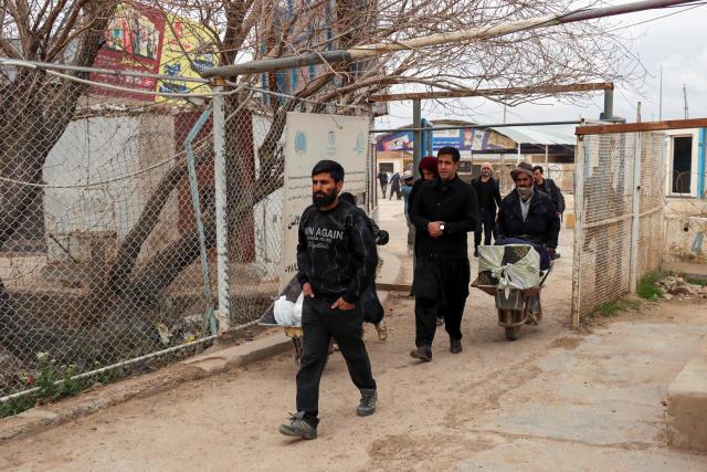 Afghan nationals arrive with their belongings at the Islam Qala border crossing between Afghanistan and Iran in Herat province on March 10, 2026, upon their arrival from Iran amid the Middle East war. (Photo by Mohsen KARIMI / AFP)