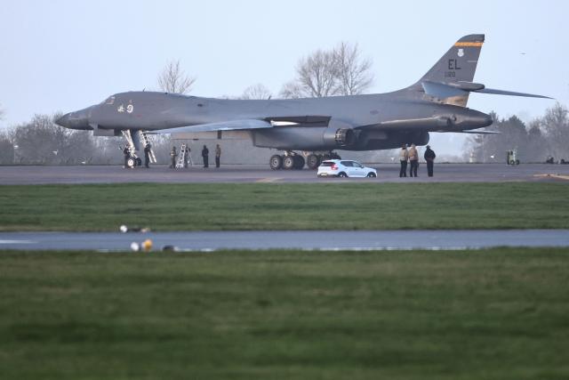 Personnel stand around a US Air Force B-1 Lancer bomber parked on the tarmac after it landed at RAF Fairford in south-west England on March 11, 2026. Fairford is one of two bases, along with the Diego Garcia facility in the Indian Ocean, that the UK has given the US permission to use for "specific defensive operations into Iran" to destroy Iranian missiles at source, the British defence minister said in a statement. (Photo by Henry NICHOLLS / AFP)