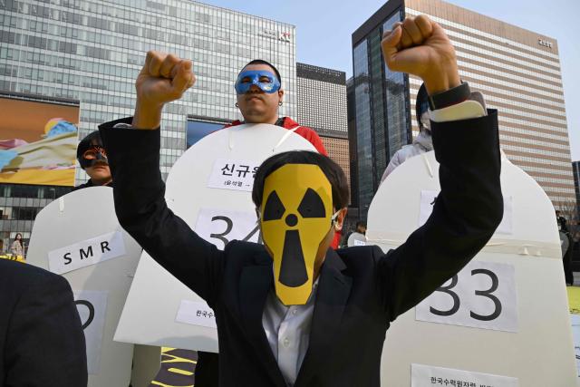A protester wearing a mask of radioactive sign performs during an anti-nuclear rally to mark the 15th anniversary of Japan's Fukushima nuclear disaster in Seoul on March 11, 2026. (Photo by Jung Yeon-je / AFP)