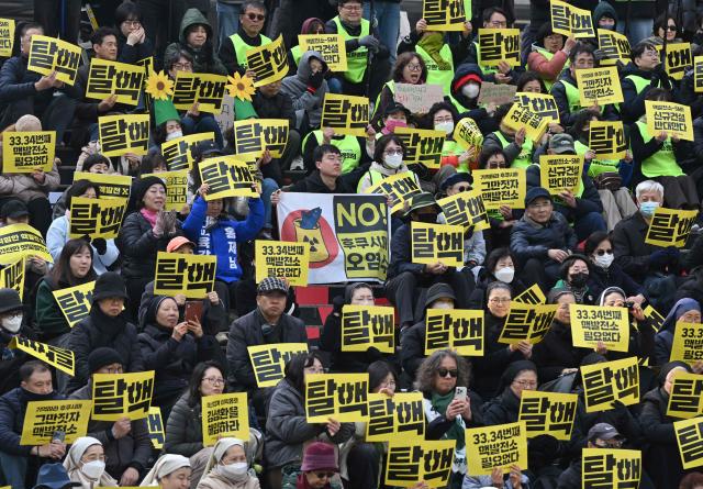 Protesters hold placards reading "No nukes" during an anti-nuclear rally to mark the 15th anniversary of Japan's Fukushima nuclear disaster in Seoul on March 11, 2026. (Photo by Jung Yeon-je / AFP)