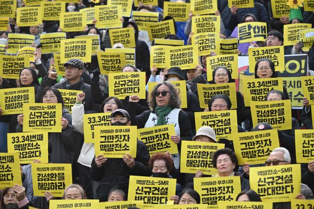 Protesters hold placards reading "Remember Fukushima, Stop building nuclear power plants" during an anti-nuclear rally to mark the 15th anniversary of Japan's Fukushima nuclear disaster in Seoul on March 11, 2026. (Photo by Jung Yeon-je / AFP)