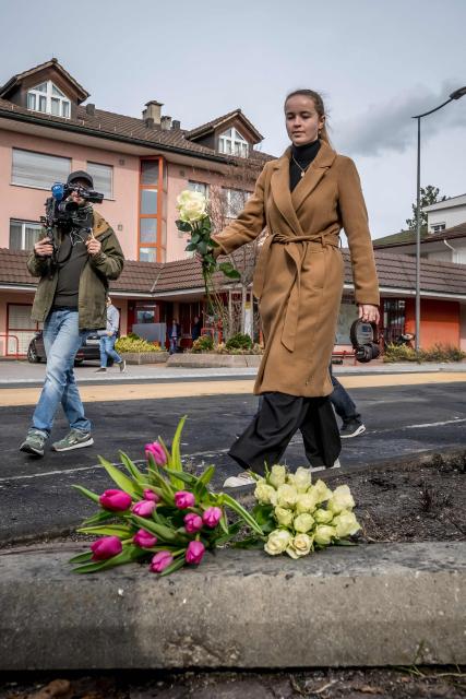 A woman lays flowers on March 11, 2026 in Kerzers, western Switzerland where a bus caught fire on March 10, 2026 killing at least six people and injuring five others in what police said may have been a deliberate act. (Photo by Fabrice COFFRINI / AFP)
