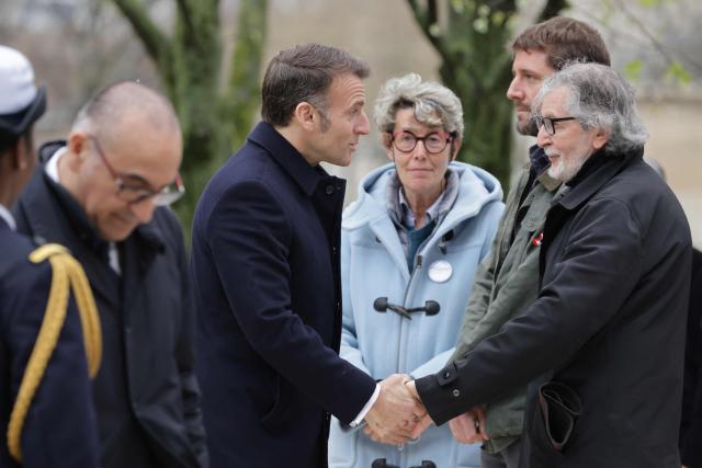 French President Emmanuel Macron (C) greets representatives of victims' associations as he arrives for a ceremony paying tribute to the victims of terrorism at Les Invalides in Paris on March 11, 2026. (Photo by Ludovic MARIN / POOL / AFP)