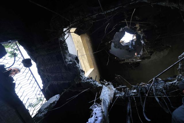 Palestinians inspect damage which according to them was caused by fragments of an intercepted Iranian rocket that landed on a Palestinian three-story building in the West Bank town of Bidya, west of Salfit, on March 11, 2026. Israel's military said on March 11 it had begun a new "wide-scale wave of strikes" across Iran and was also hitting Hezbollah infrastructure in Lebanon's capital Beirut. The fresh strikes targeting what the Israeli army called "Iranian terror regime infrastructure" came on the 12th day of the US-Israeli war with Tehran. (Photo by JAAFAR ASHTIYEH / AFP)
