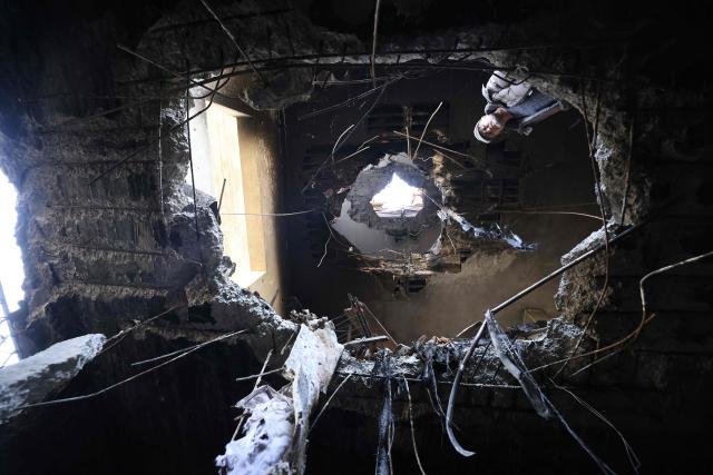A Palestinian man looks at damage which according to residents was caused by fragments of an intercepted Iranian rocket that landed on a Palestinian three-story building in the West Bank town of Bidya, west of Salfit, on March 11, 2026. Israel's military said on March 11 it had begun a new "wide-scale wave of strikes" across Iran and was also hitting Hezbollah infrastructure in Lebanon's capital Beirut. The fresh strikes targeting what the Israeli army called "Iranian terror regime infrastructure" came on the 12th day of the US-Israeli war with Tehran. (Photo by JAAFAR ASHTIYEH / AFP)