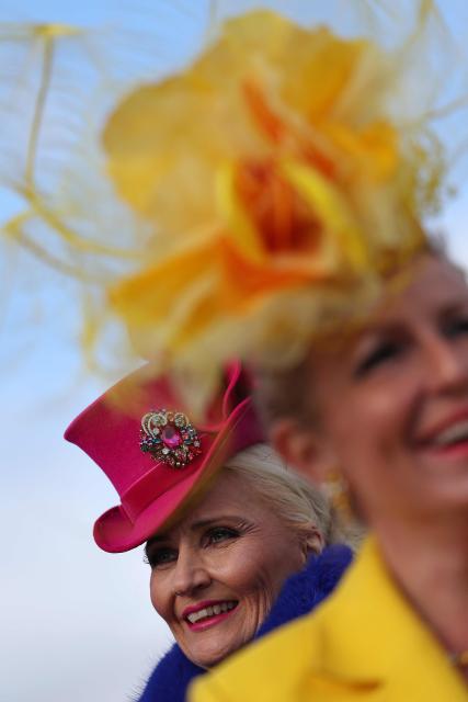 Racegoers pose for photographs as they arrive on the second day of the Cheltenham Festival at Cheltenham Racecourse, in Cheltenham, western England on March 11, 2026. (Photo by Adrian Dennis / AFP)