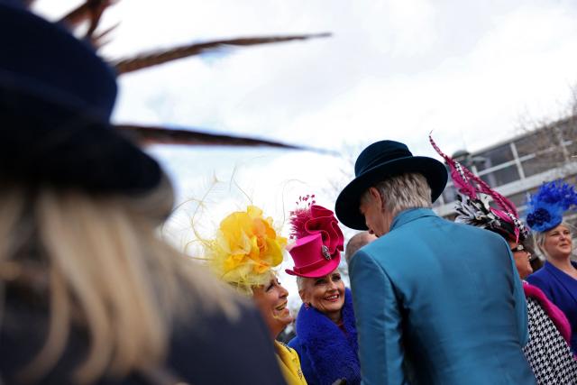 Racegoers pose for photographs as they arrive on the second day of the Cheltenham Festival at Cheltenham Racecourse, in Cheltenham, western England on March 11, 2026. (Photo by Adrian DENNIS / AFP)