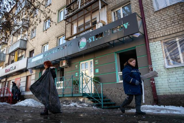 People clear debris at the site of a recent Ukrainian missile strike in Bryansk on March 11, 2026. A Ukrainian missile strike on the western Russian city of Bryansk killed seven people and wounded 42, according to the region's governor's latest update. (Photo by Andrey BORODULIN / AFP)