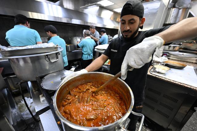 A worker prepares the "iftar" fast-breaking meal for fasting Muslims during the Muslim holy month of Ramadan, at a restaurant in Kuwait City on March 11, 2026. The oil-rich Gulf has borne the brunt of Iran's attacks in response to US-Israeli strikes that sparked the Middle East war, with Tehran targeting US assets but also civilian infrastructure, including energy facilities and airports. (Photo by YASSER AL-ZAYYAT / AFP)