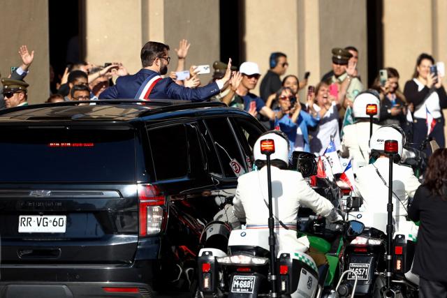 Chile's President Gabriel Boric waves to supporters as he leaves La Moneda presidential palace to travel to Valparaiso to attend the inauguration ceremony of Chile's new President Jose Antonio Kast, in Santiago, on March 11, 2026. Chile's most right-wing president in over three decades, Jose Antonio Kast, takes office on March 11, 2026, on a promise to tackle surging rates of violent crime and carry out mass migrant deportations. (Photo by Raul BRAVO / AFP)