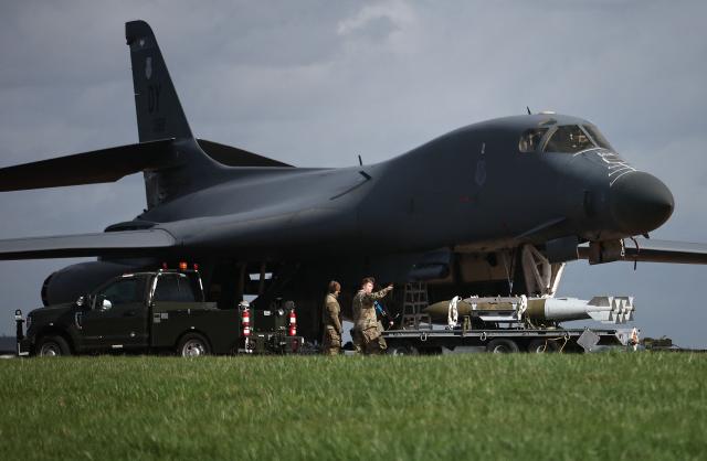 Military ground personnel transport Joint Direct Attack Munitions (JDAM)   to a US Air Force (USAF) B-1 Lancer bomber on the tarmac at RAF Fairford in south-west England on March 11, 2026. Fairford is one of two bases, along with the Diego Garcia facility in the Indian Ocean, that the UK has given the US permission to use for "specific defensive operations into Iran" to destroy Iranian missiles at source, the British defence minister said in a statement. (Photo by Henry Nicholls / AFP)
