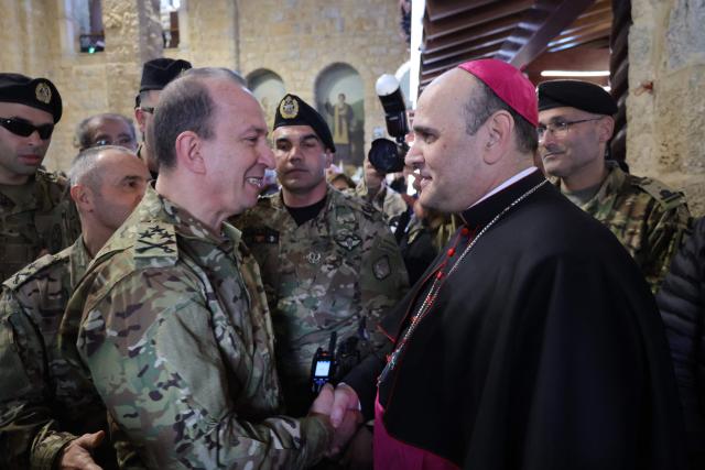 Lebanese Army Commander in Chief Rudolphe Haiykal (L) is greeted by Apostolic Nuncio to lebanon Archbishop Paolo Borjia (R) at St. Georges Maronite Church in the Christian Lebanese border village of Qlayaa during the funeral of a slain priest, Father Pierre al-Rahi on March 11, 2026. Fighting flared last week between Israel and Lebanese militant group Hezbollah as part of a wider regional war, prompting the Israeli military to warn people across swathes of southern Lebanon to flee. Farther east in the village of Qlayaa, a parish priest died on March 9 of wounds sustained from Israeli tank fire, sparking anger and fear. (Photo by Rabih DAHER / AFP)