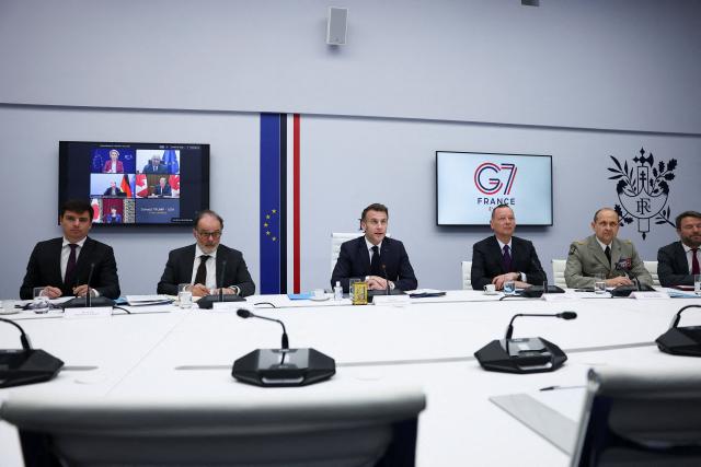 French President Emmanuel Macron (C), next to Head Economic adviser Matthieu Landon (L), Secretary General of the French Presidency Emmanuel Moulin (2ndL), Chief of the Military Staff of the President of the Republic Vincent Giraud (2ndR) and Diplomatic adviser to President, Emmanuel Bonne (3rdR), chairs a video conference of G7 leaders to discuss the fallout of the war in Iran on the world economy, amid the US-Israeli war on Iran, at the Elysee Palace in Paris, on March 11, 2026. (Photo by Gonzalo Fuentes / POOL / AFP)