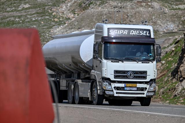 An Iranian fuel oil tanker drives en route to Sulaimaniyah in Iraq's northern Kurdistan region after passing the Bashmagh border crossing on March 11, 2026. The International Energy Agency said its member countries would unlock 400 million barrels of oil from their reserves to ease the impact of the Middle East war, the biggest such release ever. The crude market has been hit by wild volatility since the United States and Israel began striking Iran at the end of last month, with Tehran retaliating by attacking targets across the oil-rich Gulf and effectively shutting down the Strait of Hormuz. (Photo by Ozan KOSE / AFP)