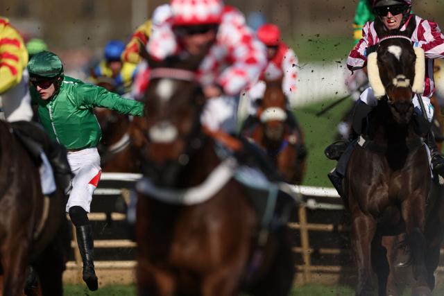 Jockey Eoin Staples (L) falls from racehorse Hms Seahorse after clearing a fence in the BetMGM Cup Handicap Hurdleon the second day of the Cheltenham Festival at Cheltenham Racecourse, in Cheltenham, western England on March 11, 2026. (Photo by Adrian Dennis / AFP)