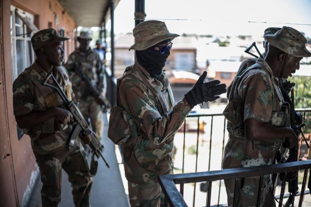 South African National Defence Force (SANDF) soldiers conduct a house search in Westbury, Johannesburg, on March 11, 2026. Soldiers moved into gang-violence hotspots in Johannesburg on March 11, 2026 to support police efforts to tackle rampant crime, described by President Cyril Ramaphosa as one of the biggest threats facing South Africa. (Photo by MARCO LONGARI / AFP)
