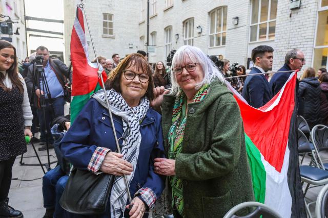 Supporters of punk-rap group Kneecap pose outside the Conway Mill in Belfast on March 11, 2026, before a press conference by the band. Liam O'Hanna, the Irish-language singer from punk-rap group Kneecap will not face a terrorism charge after UK prosecutors lost a High Court challenge on March 11 against a judge's decision to dismiss the case. (Photo by Paul Faith / AFP)