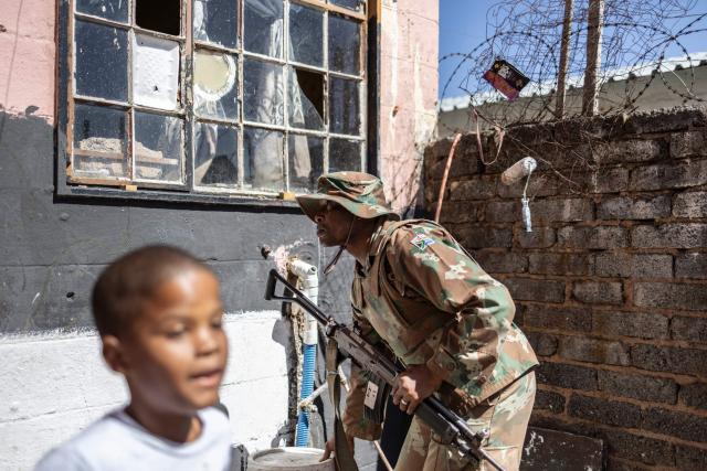 A South African National Defence Force (SANDF) soldier keeps an eye during a house search in a patrol operation in Westbury, near Johannesburg, on March 11, 2026. Soldiers moved into gang-violence hotspots in Johannesburg on March 11, 2026 to support police efforts to tackle rampant crime, described by President Cyril Ramaphosa as one of the biggest threats facing South Africa. (Photo by ILARIA FINIZIO / AFP)