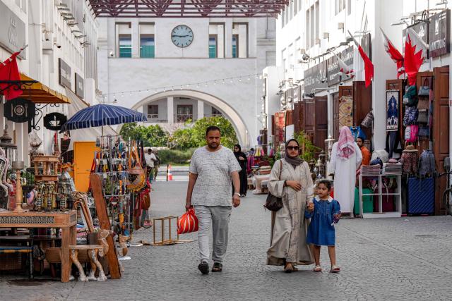 People walk along an alley at a bazaar in Bahrain's capital Manama on March 11, 2026. Iran's Revolutionary Guards said on March 11 that they had targeted several US bases in Kuwait and Bahrain during the war with the United States and Israel. (Photo by AFP) / 
