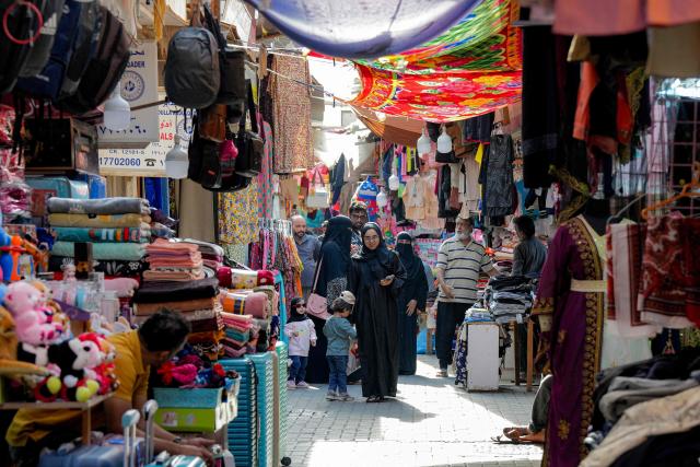 People walk along an alley at a bazaar in Bahrain's capital Manama on March 11, 2026. Iran's Revolutionary Guards said on March 11 that they had targeted several US bases in Kuwait and Bahrain during the war with the United States and Israel. (Photo by AFP) / 