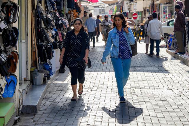 People walk along an alley at a bazaar in Bahrain's capital Manama on March 11, 2026. Iran's Revolutionary Guards said on March 11 that they had targeted several US bases in Kuwait and Bahrain during the war with the United States and Israel. (Photo by AFP) / 