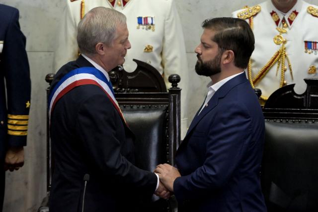 Chile’s new President Jose Antonio Kast (R), wearing the presidential sash, shakes hands with Chile’s outgoing President Gabriel Boric at the National Congress in Valparaiso, Chile, on March 11, 2026. Chile's most right-wing president in over three decades, Jose Antonio Kast, takes office on March 11, 2026, on a promise to tackle surging rates of violent crime and carry out mass migrant deportations. (Photo by RODRIGO ARANGUA / AFP)