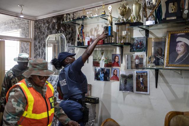 A South Africa Police Service (SAPS) officer searches a house during a joint operation with South African National Defence Force (SANDF) soldiers in Westbury, Johannesburg, on March 11, 2026. Soldiers moved into gang-violence hotspots in Johannesburg on March 11, 2026 to support police efforts to tackle rampant crime, described by President Cyril Ramaphosa as one of the biggest threats facing South Africa. (Photo by ILARIA FINIZIO / AFP)