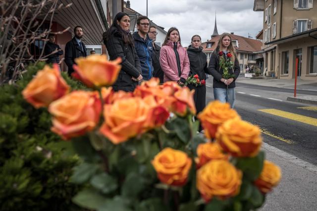 People People with flowers stand during a memorial ceremony in Kerzers, western Switzerland on March 11, 2026, the day after six people were killed in a bus fire which was seemingly started by a disturbed man on board who set himself alight. (Photo by Fabrice COFFRINI / AFP)
