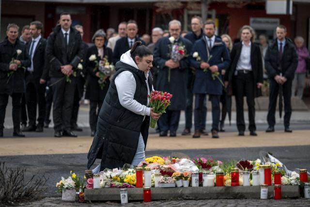 A women holds flower in front of Switzerland's President Guy Parmelin during a memorial ceremony in Kerzers, western Switzerland on March 11, 2026, the day after six people were killed in a bus fire which was seemingly started by a disturbed man on board who set himself alight. (Photo by Fabrice COFFRINI / AFP)