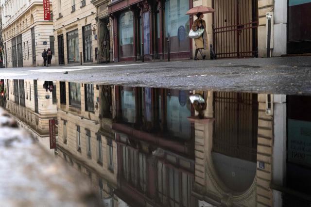 A pedestrian walks with an umbrella on a rainy day in Paris on March 11, 2026. (Photo by JOEL SAGET / AFP)