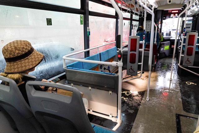 A passenger sits on a bus on a rainy day in Paris on March 11, 2026. (Photo by JOEL SAGET / AFP)