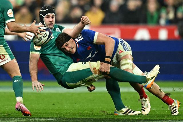 (FILES) Ireland's number number eight Caelan Doris is tackled by France's flanker Oscar Jegou during the Six Nations international rugby union match between France and Ireland at the Stade de France in Saint-Denis, Paris' suburb, on February 5, 2026. The French flanker was suspended for four matches for putting his hand in the face of an opponent in a maul during the Six Nations international rugby union match between Scotland and France, touching his eyes in the process, the disciplinary committee of the Six Nations Tournament decided on March 11, 2026. The La Rochelle player will now miss the final match of the Six Nations Tournament against England on March 14, having started the first four matches of the Championship (Photo by Julie SEBADELHA / AFP)
