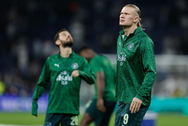 Manchester City's Norwegian forward #09 Erling Haaland (R) and Manchester City's Portuguese midfielder #20 Bernardo Silva warm up before the UEFA Champions League last 16 first leg football match between Real Madrid CF and Manchester City at Santiago Bernabeu Stadium in Madrid on March 11, 2026. (Photo by Oscar DEL POZO / AFP)