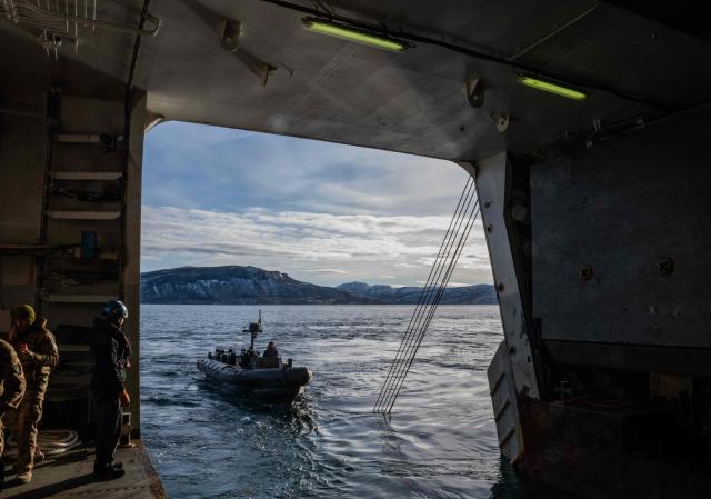 Sailors operate an outboard boat near the San Giusto, a San Giorgio-class amphibious transport dock of the Italian Navy, off the coast of Harstad on March 11, 2026, as NATO conducts its Cold Response military exercise. The Norwegian-led winter exercise involves 32.000 troops, 100 aircraft, and 30 warships from 14 nations taking part in high intensity, multi-domain operations in an arctic climate. (Photo by John MACDOUGALL / AFP)