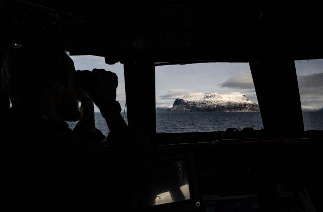 The captain of a Skjold-class Corvette of the Norwegian Navy looks through his binoculars as the ship manoeuvres off the coast of Harstad on March 11, 2026, as NATO conducts its Cold Response military exercise. The Norwegian-led winter exercise involves 32.000 troops, 100 aircraft, and 30 warships from 14 nations taking part in high intensity, multi-domain operations in an arctic climate. (Photo by John MACDOUGALL / AFP)