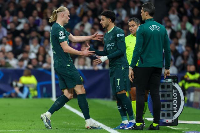 Manchester City's Norwegian forward #09 Erling Haaland (L) is substituted by Manchester City's Egyptian forward #07 Omar Marmoush during the UEFA Champions League last 16 first leg football match between Real Madrid CF and Manchester City at Santiago Bernabeu Stadium in Madrid on March 11, 2026. (Photo by Thomas COEX / AFP)